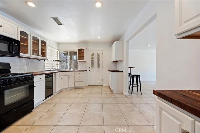 kitchen with black appliances, glass insert cabinets, and white cabinetry