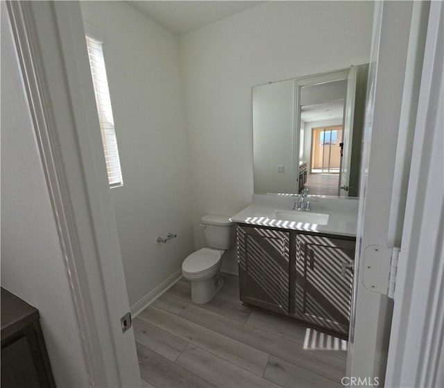 bathroom featuring vanity, toilet, and hardwood / wood-style floors