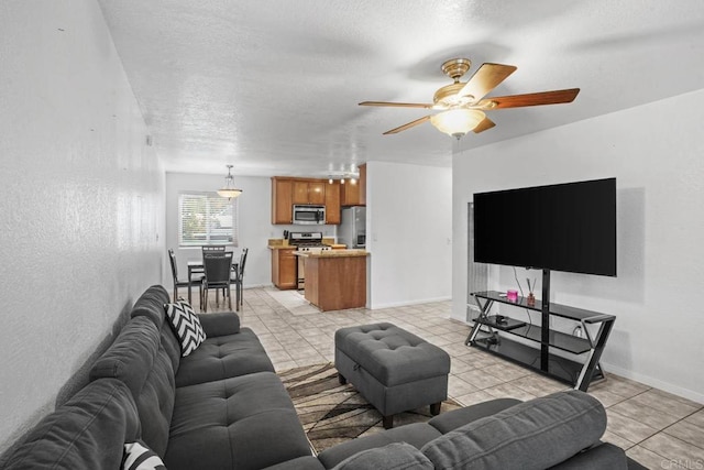 tiled living room featuring a textured ceiling and ceiling fan