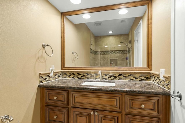 full bath featuring decorative backsplash, visible vents, a shower stall, and vanity