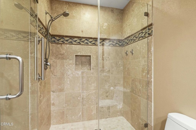 bathroom with a shower stall and toilet