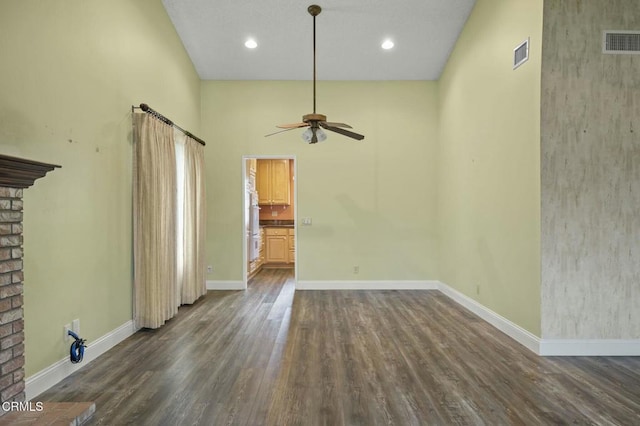 unfurnished living room featuring dark wood-type flooring, baseboards, visible vents, and ceiling fan