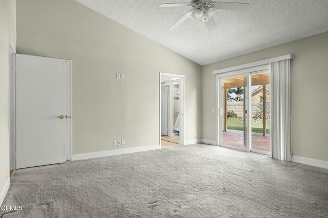 unfurnished room featuring baseboards, carpet flooring, a textured ceiling, and lofted ceiling