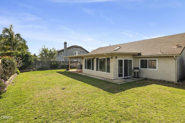 back of property with a patio area, stucco siding, a lawn, and a fenced backyard