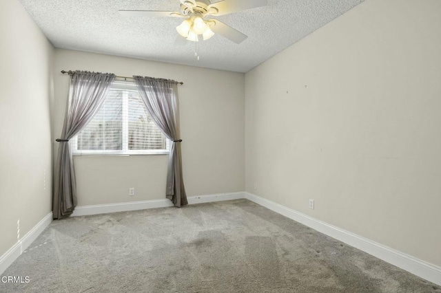 carpeted spare room featuring baseboards, a textured ceiling, and ceiling fan