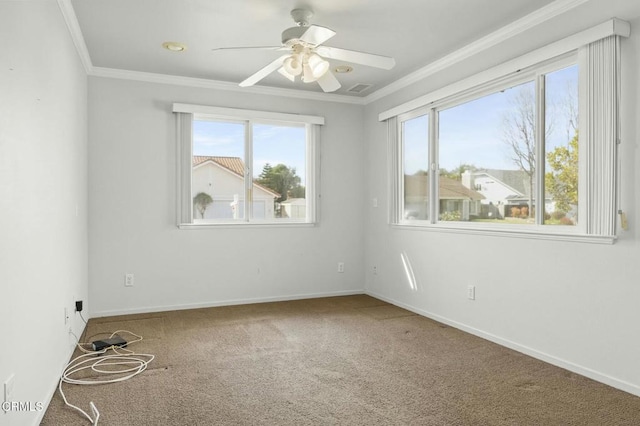 carpeted empty room featuring ceiling fan, baseboards, and ornamental molding