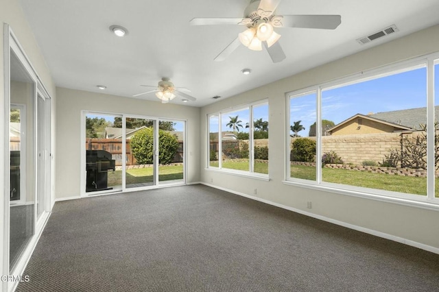 unfurnished sunroom with a ceiling fan and visible vents