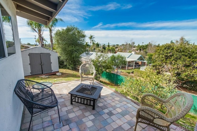 view of patio featuring a shed and a fire pit