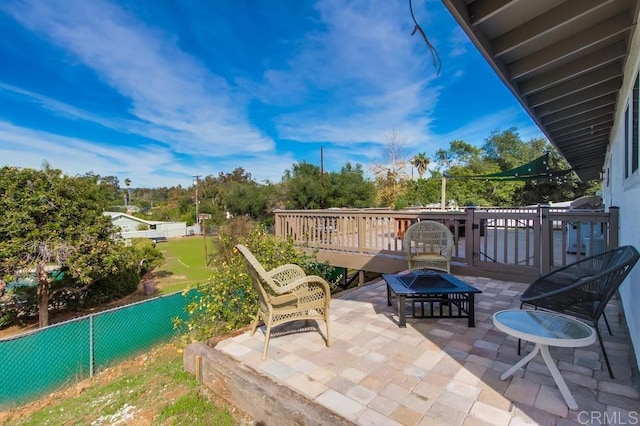 view of patio / terrace featuring a wooden deck and an outdoor fire pit