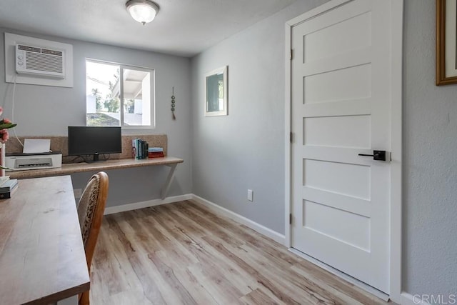 office space featuring light hardwood / wood-style floors and an AC wall unit