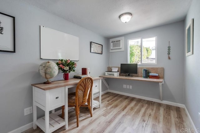 office space with a wall mounted air conditioner and light hardwood / wood-style flooring