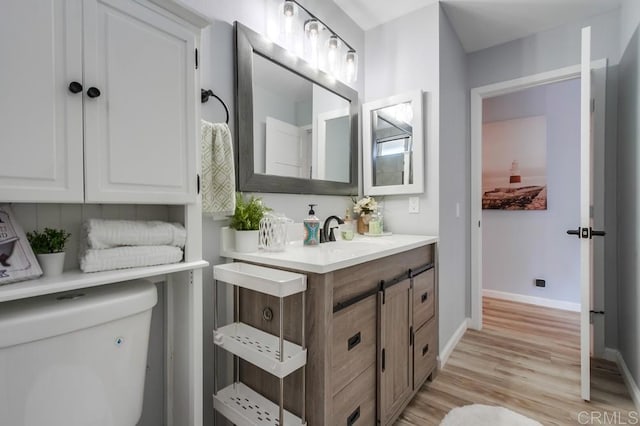 bathroom featuring toilet, vanity, and hardwood / wood-style floors