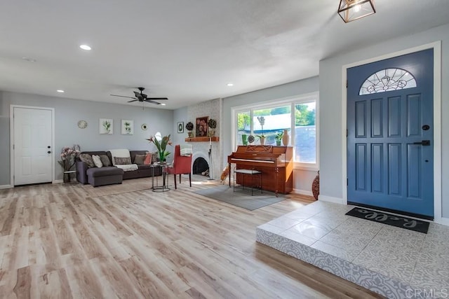 entryway featuring light wood-type flooring and a large fireplace