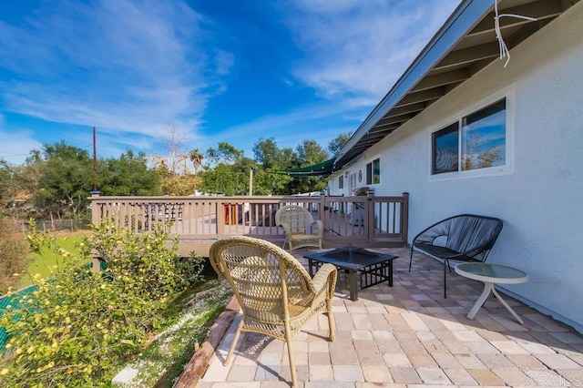 view of patio / terrace with a wooden deck and a fire pit