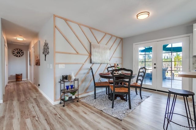 dining room with light wood-type flooring and french doors