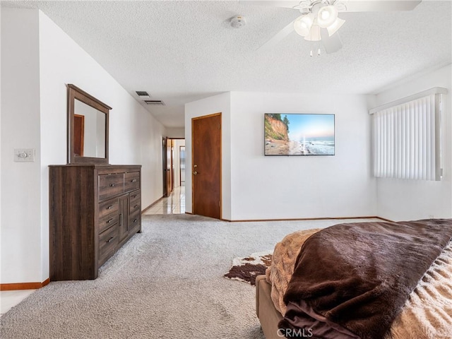 carpeted bedroom with ceiling fan and a textured ceiling