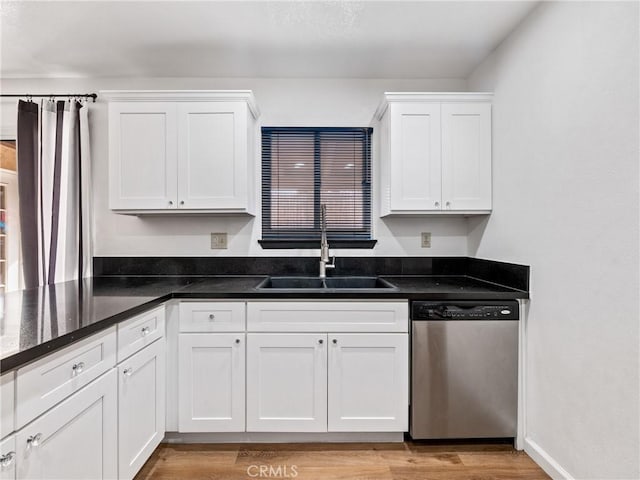 kitchen featuring white cabinets, dark stone countertops, sink, and stainless steel dishwasher