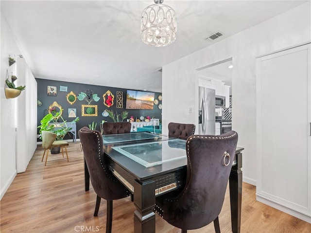 dining room featuring a notable chandelier and light hardwood / wood-style flooring