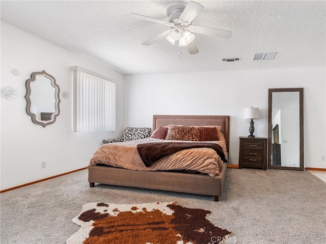 bedroom with ceiling fan, a textured ceiling, and light colored carpet