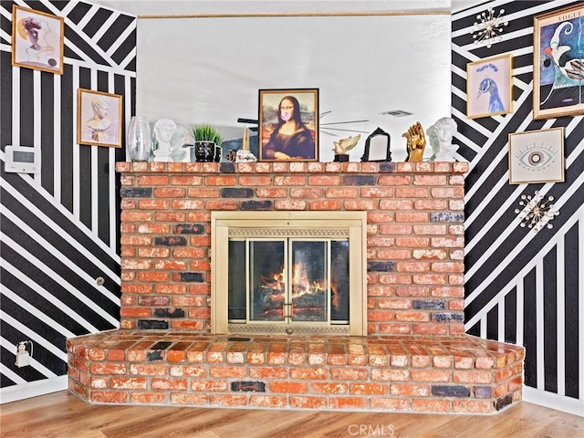 details with a brick fireplace and wood-type flooring