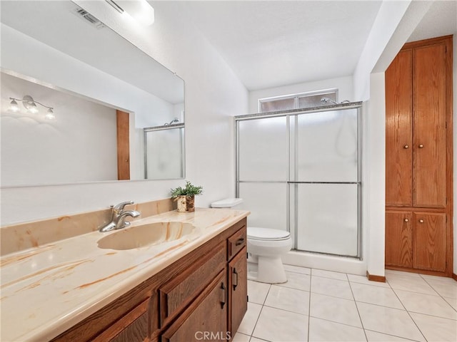 bathroom featuring toilet, tile patterned flooring, an enclosed shower, and vanity