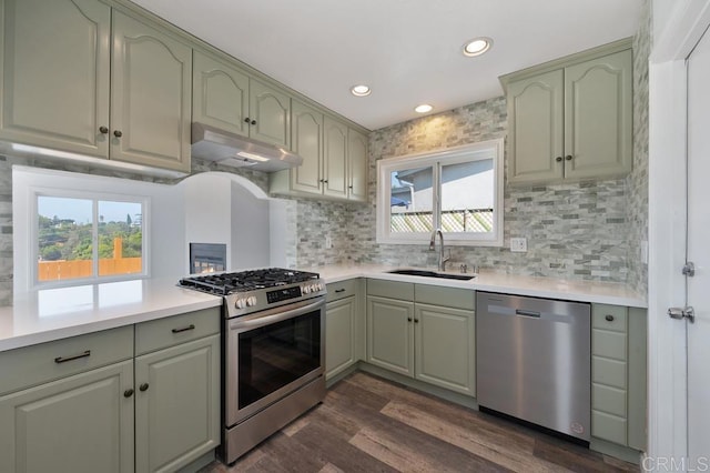 kitchen featuring stainless steel appliances, light countertops, a sink, and under cabinet range hood