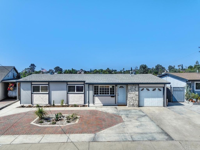 ranch-style home featuring a garage and decorative driveway