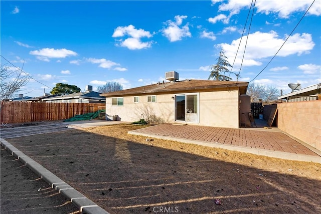 rear view of property featuring cooling unit and a deck