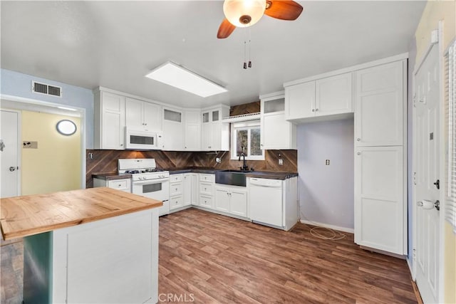 kitchen with sink, backsplash, white appliances, and white cabinets