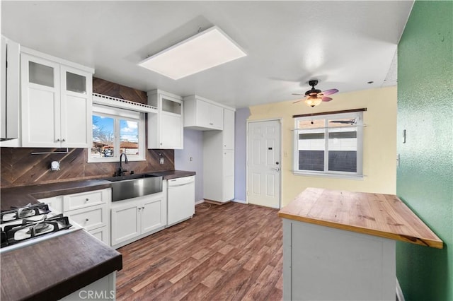 kitchen with tasteful backsplash, dishwasher, white cabinets, wood counters, and sink