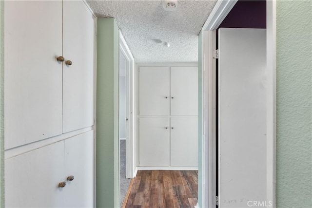 corridor featuring dark hardwood / wood-style flooring and a textured ceiling