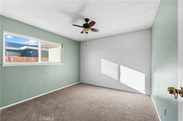 carpeted spare room with ceiling fan and a textured ceiling