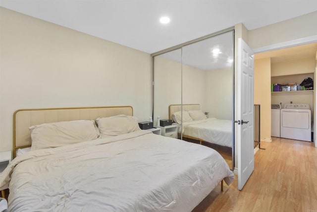 bedroom with independent washer and dryer, a closet, and light wood-type flooring