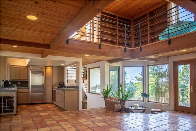 kitchen with built in refrigerator, wooden ceiling, beam ceiling, and a sink