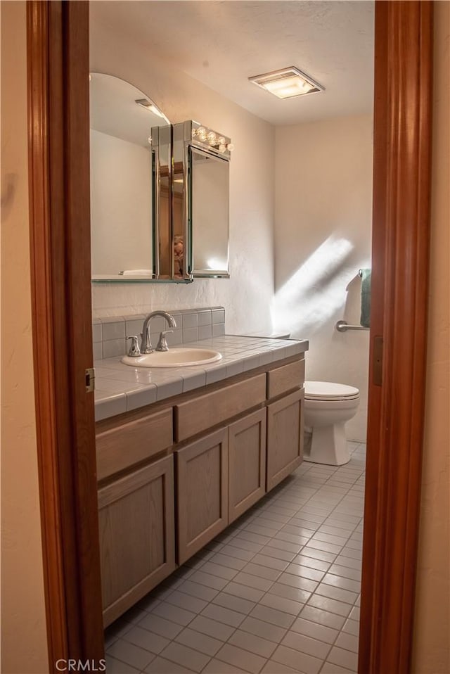 bathroom featuring toilet, tile patterned floors, and vanity