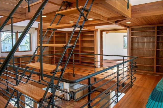 stairs with wooden ceiling, beam ceiling, and wood finished floors