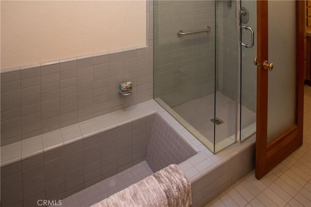 full bathroom featuring tile patterned flooring and a shower stall