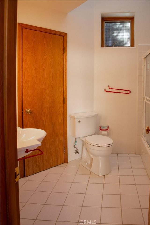 full bathroom with tile patterned flooring, combined bath / shower with glass door, and toilet