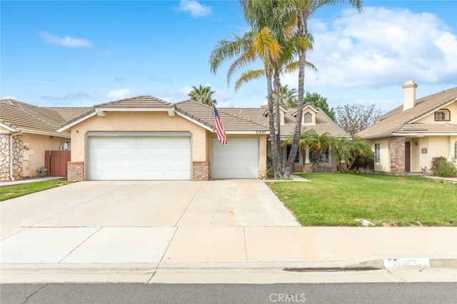 view of front of home with concrete driveway, a tiled roof, an attached garage, a front yard, and stucco siding