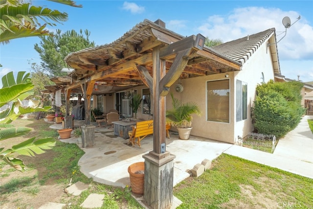 back of property with a patio and stucco siding