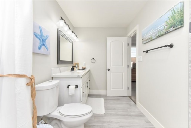 16791 Bayview Dr, Huntington Beach, CA 92649 - bathroom featuring toilet, wood finished floors, baseboards, and vanity