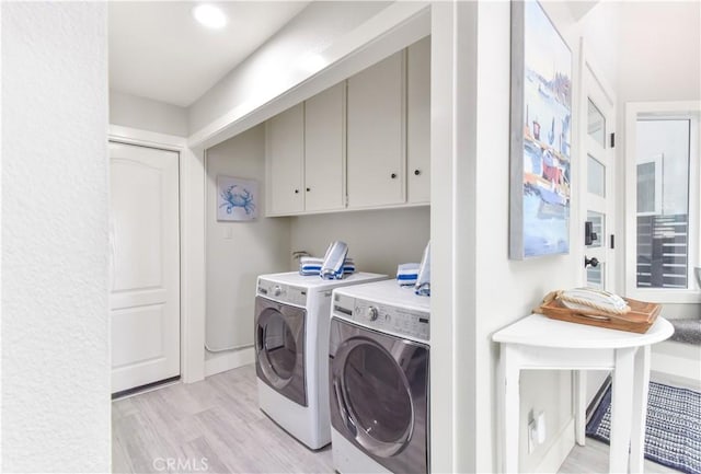 16791 Bayview Dr, Huntington Beach, CA 92649 - washroom featuring washing machine and clothes dryer, cabinet space, and light wood-type flooring
