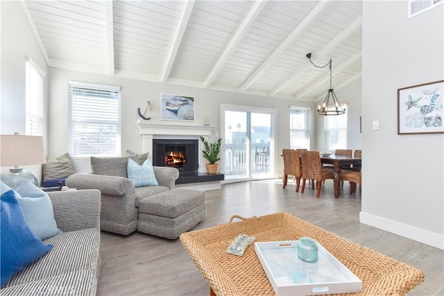 16791 Bayview Dr, Huntington Beach, CA 92649 - living area with a chandelier, a warm lit fireplace, light wood finished floors, and baseboards