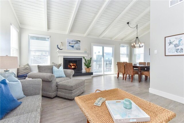 16791 Bayview Dr, Huntington Beach, CA 92649 - living area featuring a chandelier, a warm lit fireplace, light wood finished floors, and baseboards