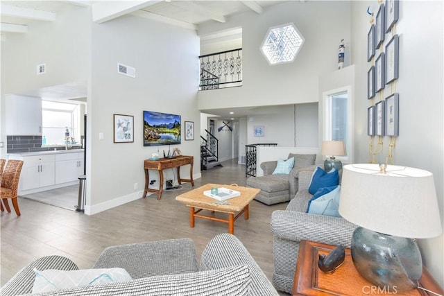 16791 Bayview Dr, Huntington Beach, CA 92649 - living area with high vaulted ceiling, stairs, beam ceiling, light wood-style floors, and baseboards