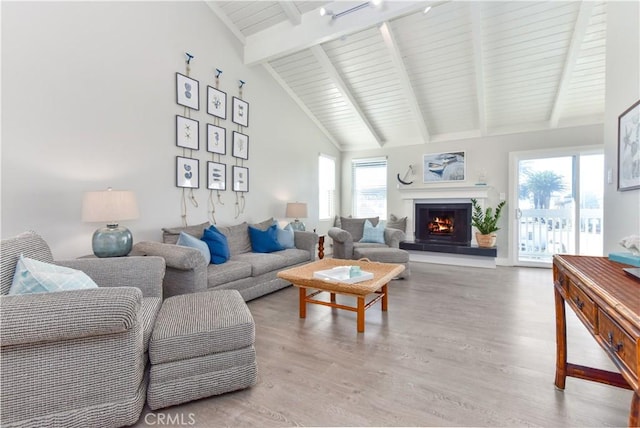 16791 Bayview Dr, Huntington Beach, CA 92649 - living area with light wood finished floors, a warm lit fireplace, beam ceiling, and high vaulted ceiling