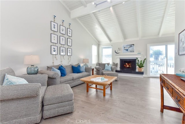 16791 Bayview Dr, Huntington Beach, CA 92649 - living area with light wood-style flooring, a lit fireplace, beamed ceiling, and high vaulted ceiling
