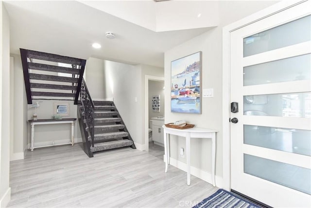 16791 Bayview Dr, Huntington Beach, CA 92649 - foyer entrance featuring stairway, wood finished floors, and baseboards