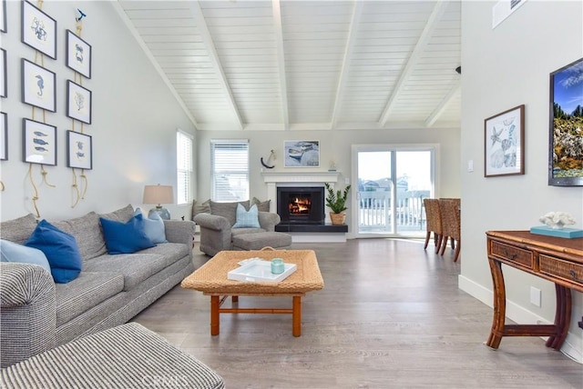16791 Bayview Dr, Huntington Beach, CA 92649 - living area featuring wood finished floors, beamed ceiling, a warm lit fireplace, baseboards, and high vaulted ceiling