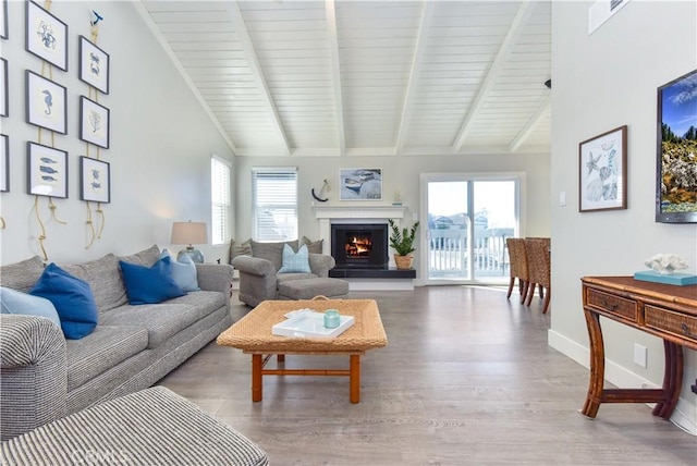 16791 Bayview Dr, Huntington Beach, CA 92649 - living room featuring wood finished floors, beam ceiling, a warm lit fireplace, baseboards, and high vaulted ceiling
